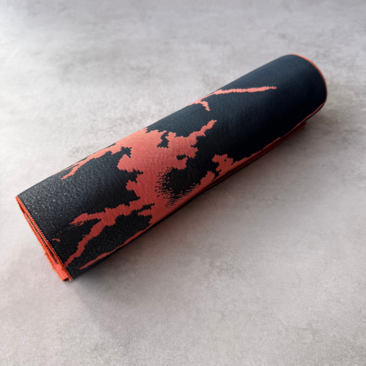 Rolled black and coral Japanese hachisun obi fabric for crafts