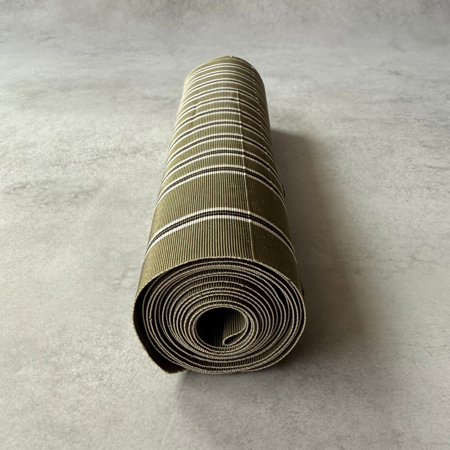 End view of rolled pre-owned olive striped obi fabric bolt